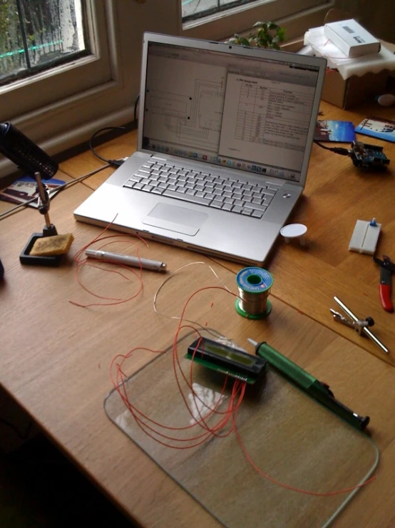 the laptop computer is open on top of the wooden table