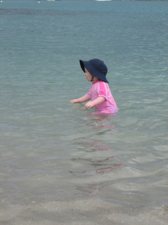 a little girl in the water throwing a frisbee