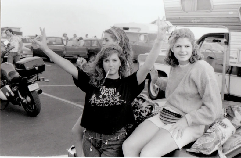 a black and white pograph of two girls on a motorcycle