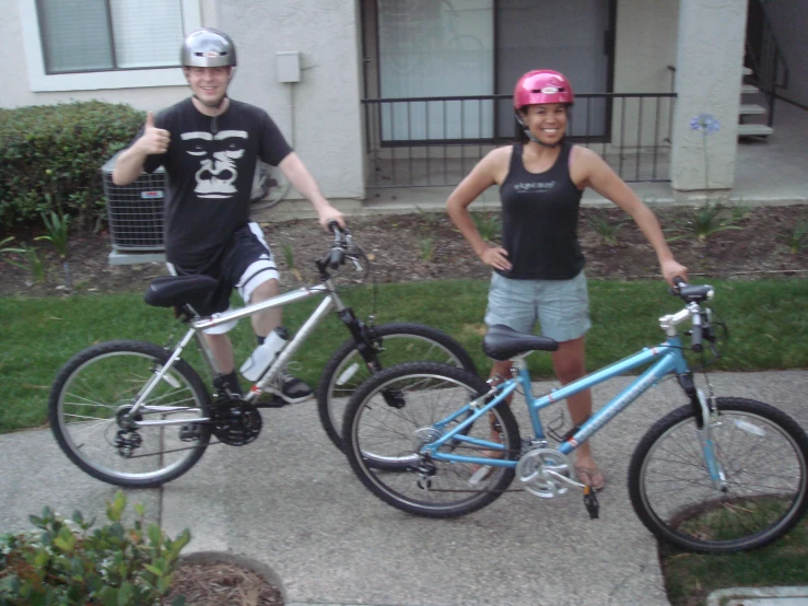 two people standing by their bikes with helmets on