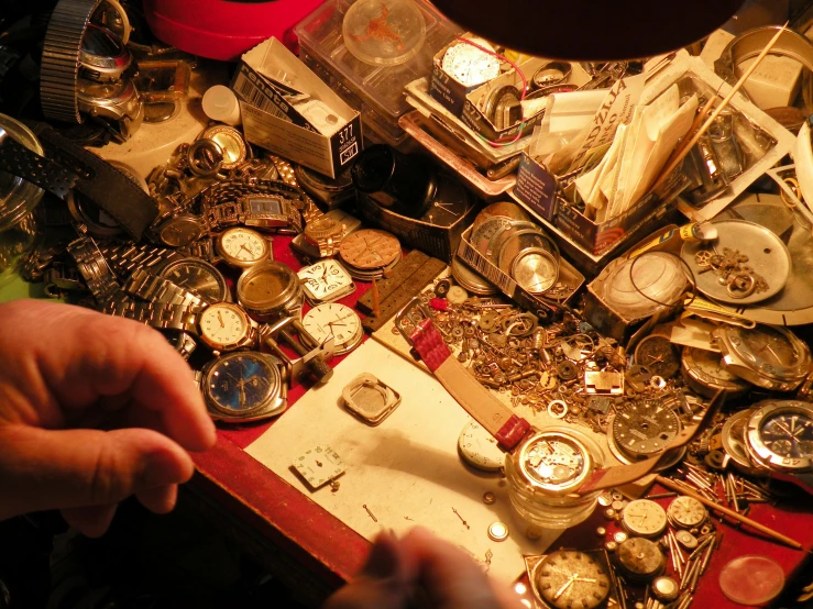 a collection of various watch parts and jewelry sitting on top of a table