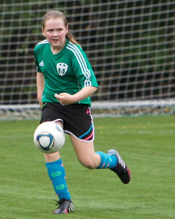 a  kicking a soccer ball around a field