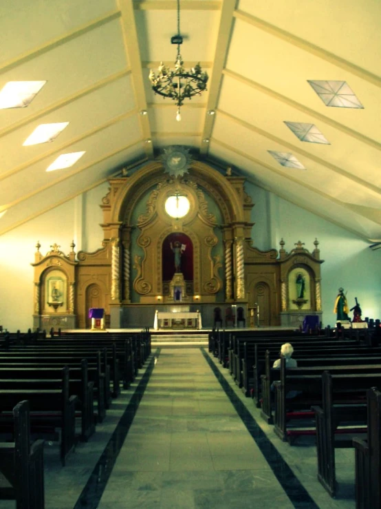 the interior of a church with pews, a chandelier, and several benches