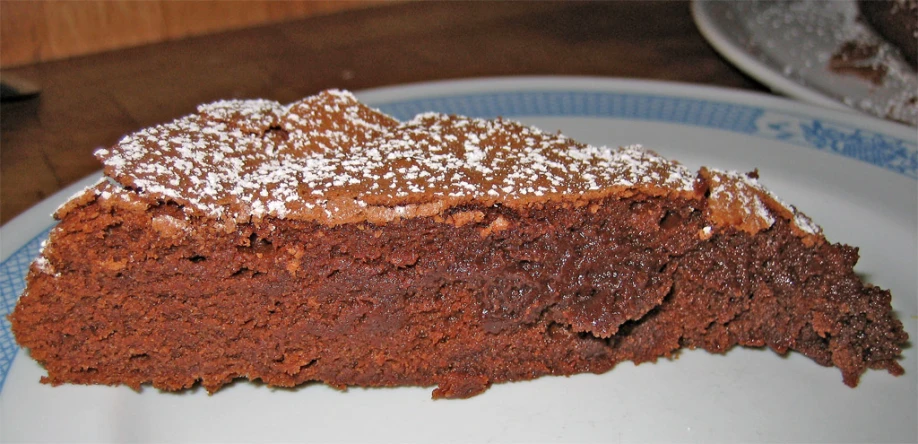 a slice of cake on a plate with powdered sugar