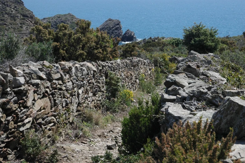 a rocky pathway going down to the ocean