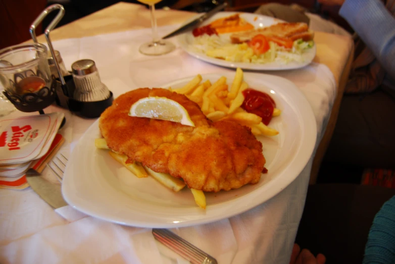 a couple plates filled with french fries and fish