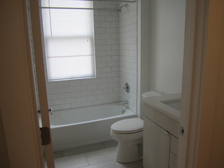 a bathroom with a white toilet sitting next to a tub
