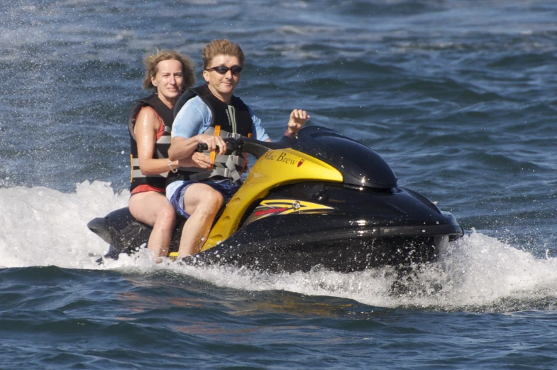 a couple riding a jet ski across the water