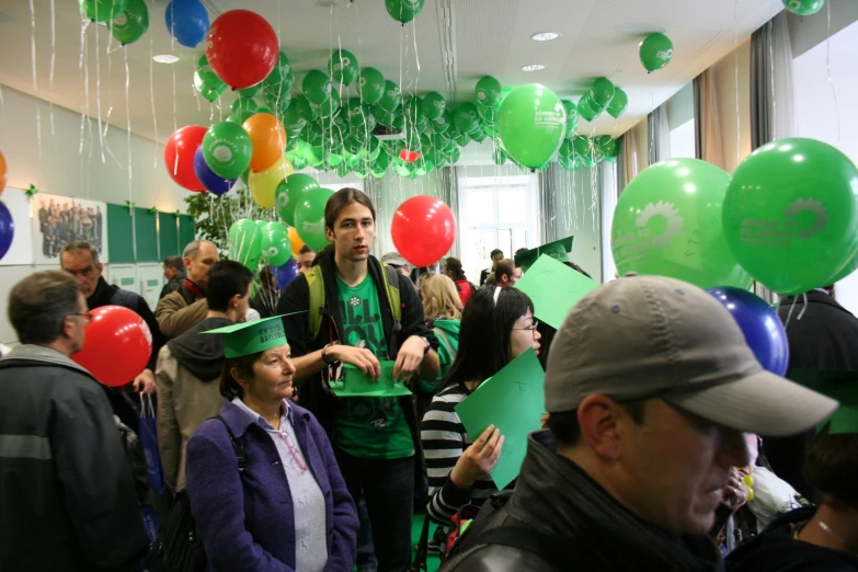 group of people wearing hats in a room with balloons
