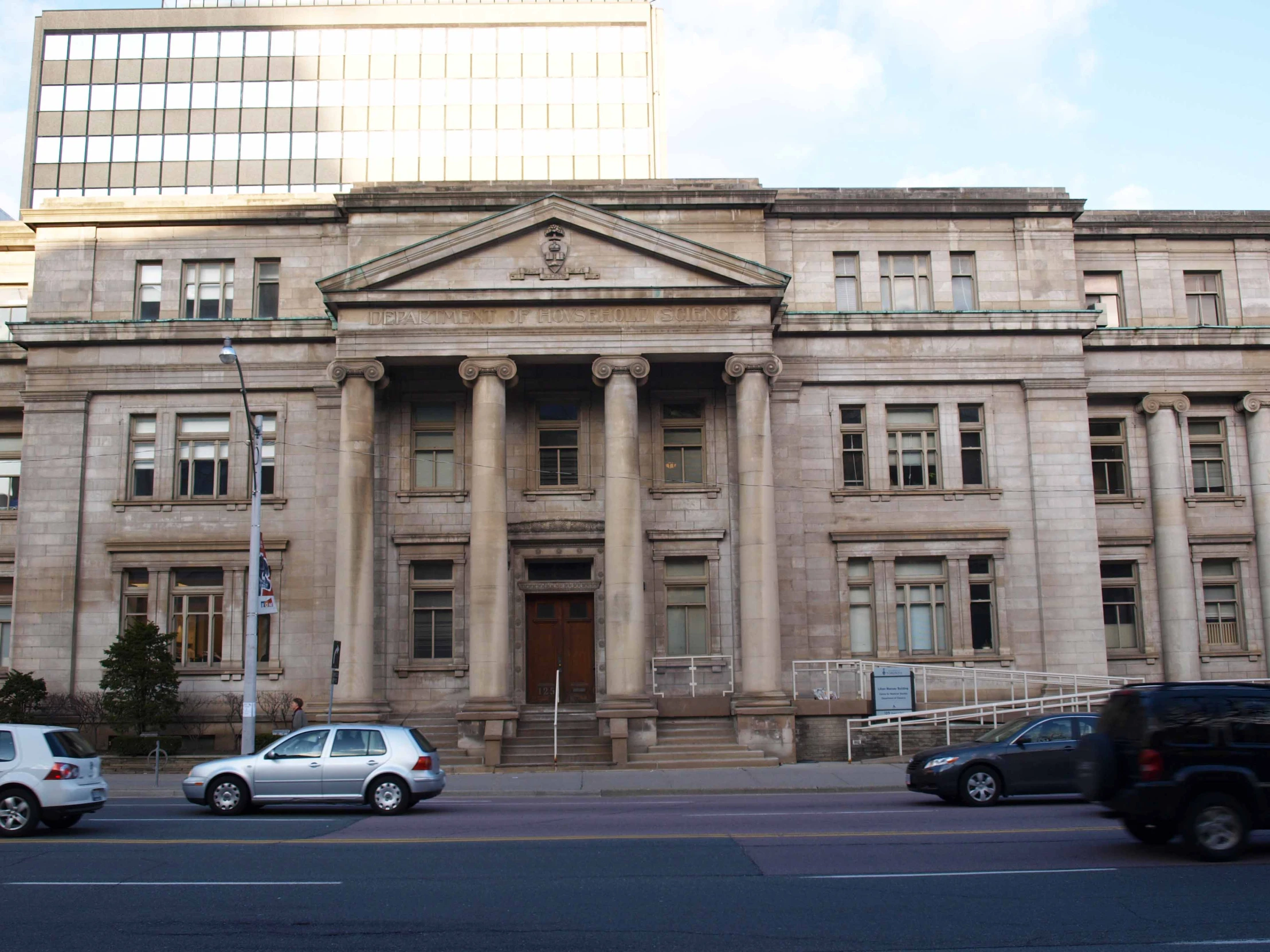 several cars drive in front of an old stone building