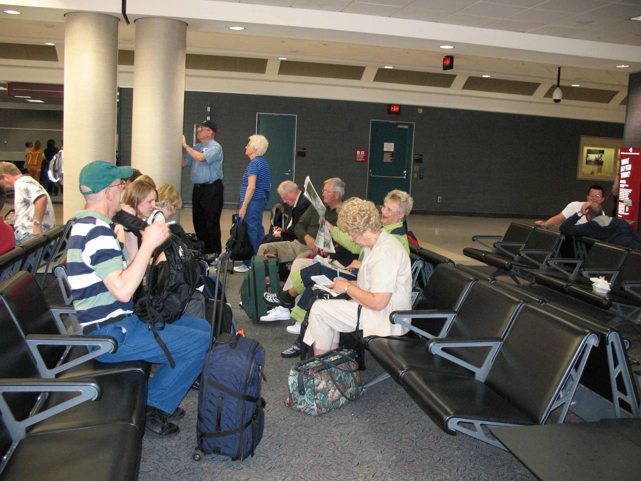 people are waiting in an airport waiting to board