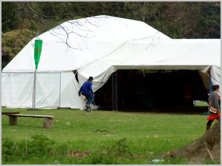 two men with bicycle next to white tents