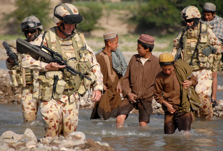 a group of soldiers walking through a river holding guns