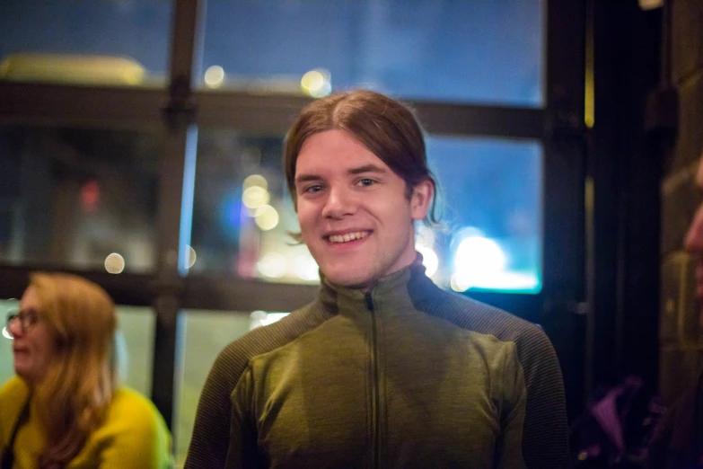 a man in green jacket smiling and standing