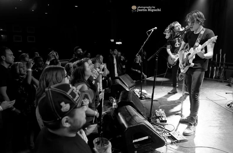 two musicians in a black and white po with lots of people