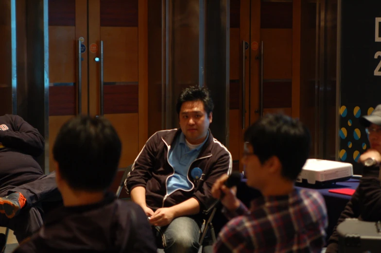 several men sit in chairs next to each other