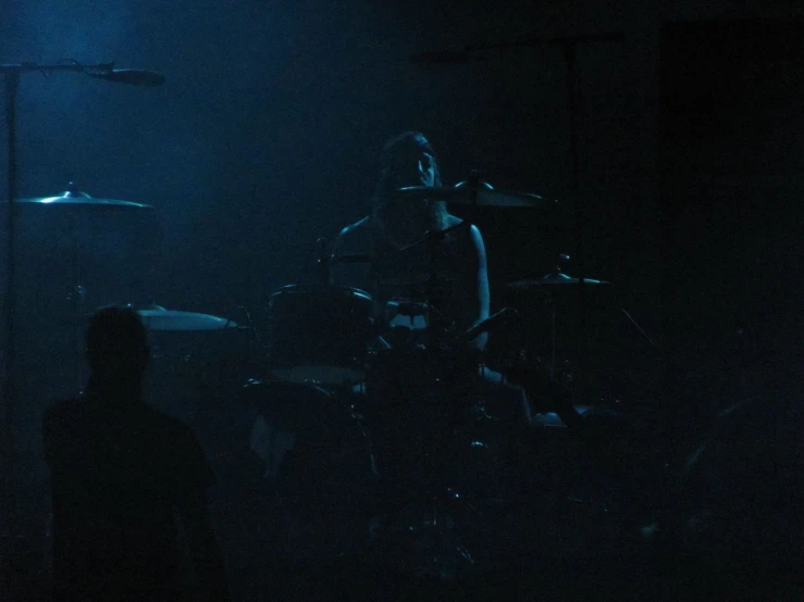 two men on stage in the dark playing instruments