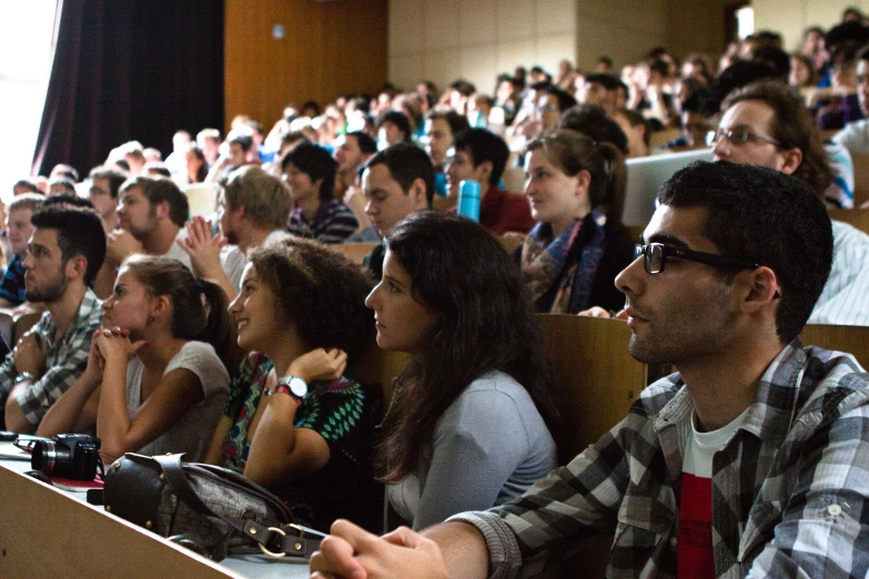 a group of people in an auditorium clapping