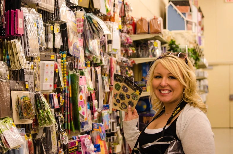 a woman in front of a wall covered with different goods