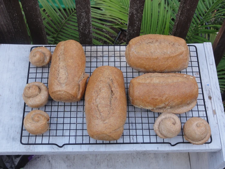 several brown bread pieces on a cooling rack next to some bananas