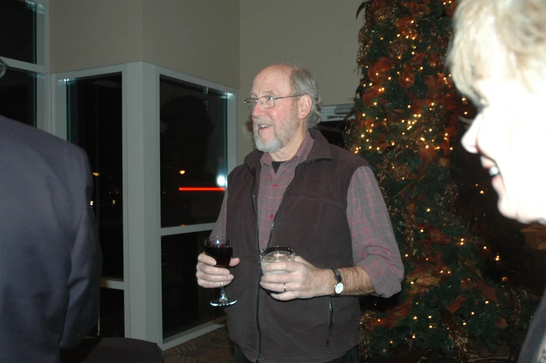 a man wearing a vest holds a wine glass