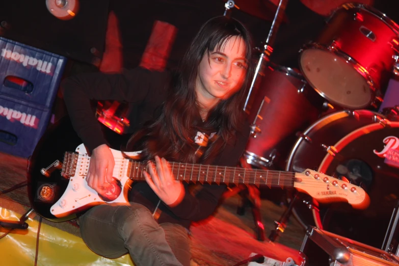 young guitarist plays music in the dark for his peers