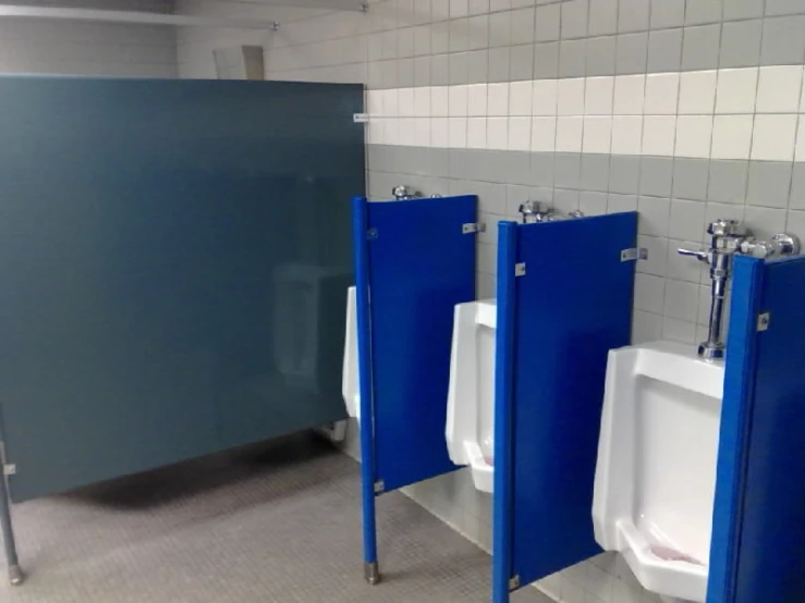 four urinals are on the walls in a men's restroom