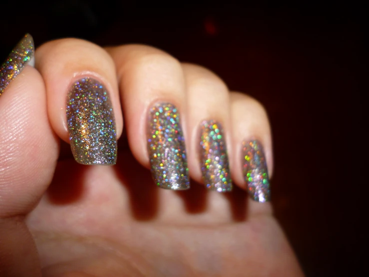 a person holding a manicured with some glitter