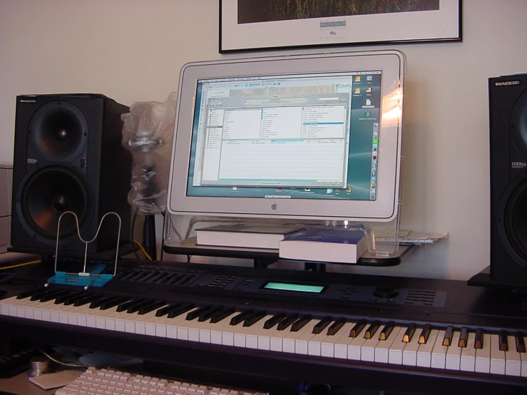 a computer monitor sitting on top of a piano keyboard