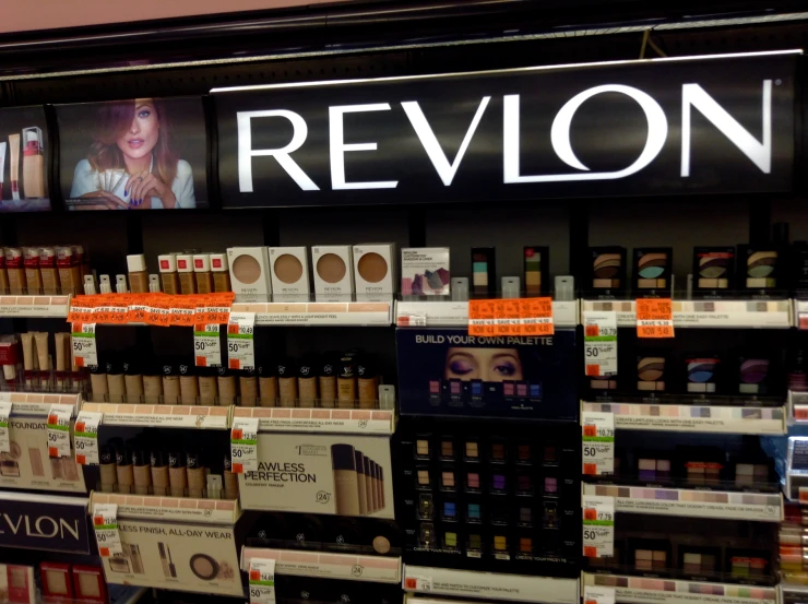 a store sign is seen above rows of makeup