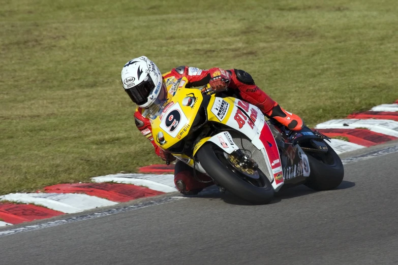 a motorcyclist leans into a turn at a track