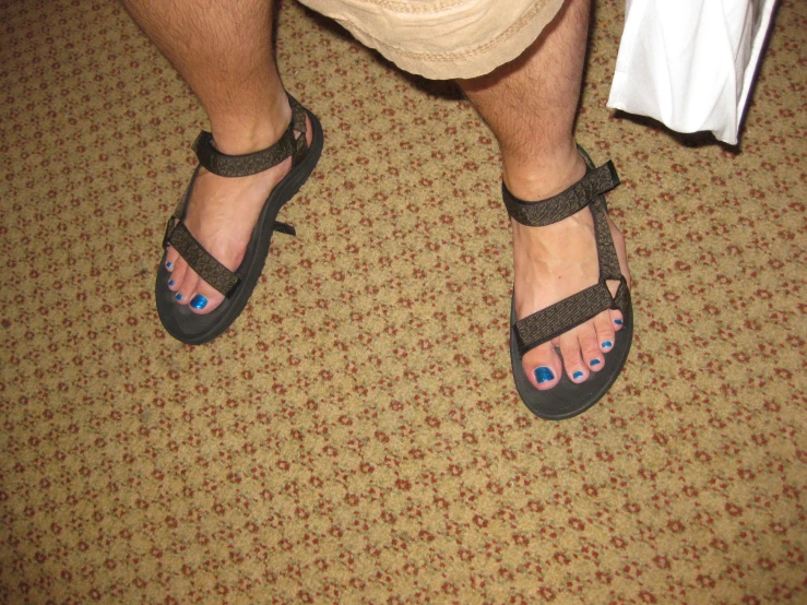 a person with a pair of sandals standing in a room