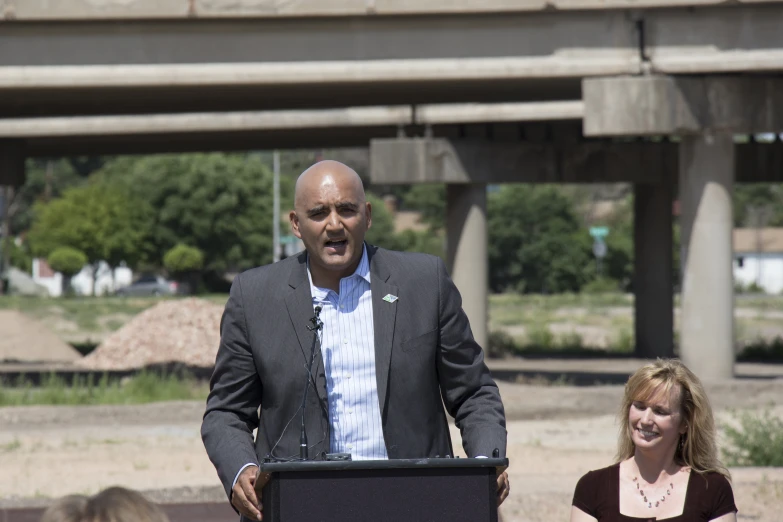 a bald headed man is making a speech to people