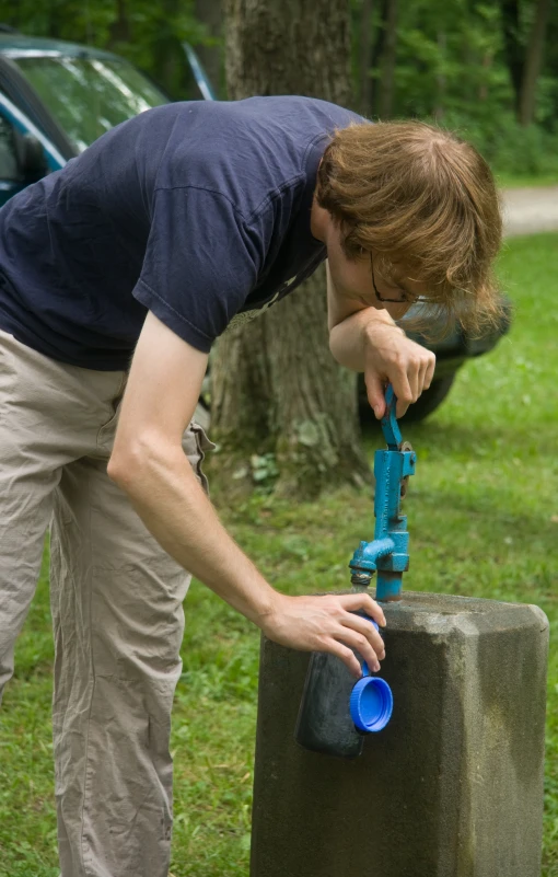 a man sprays his nose next to a cement post