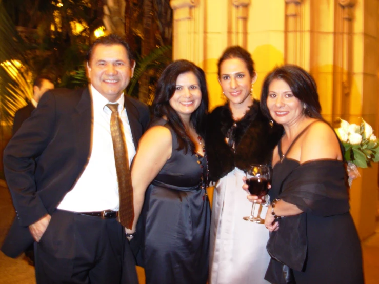 a group of three people standing together at a wedding