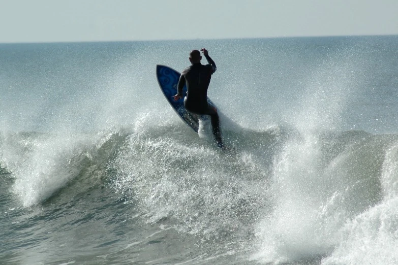 there is a man that is riding the waves on the surfboard