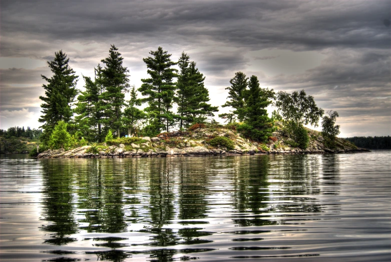 an island in the middle of a lake with a cloudy sky