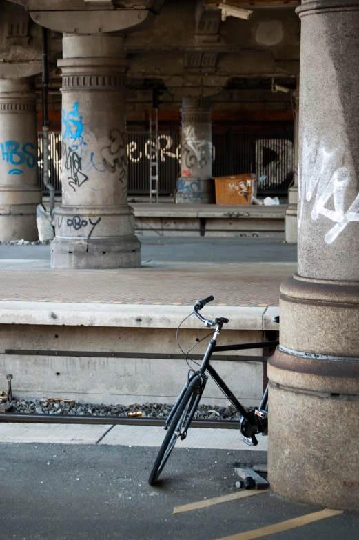 a bicycle leaning against a pillar at an underground parking garage