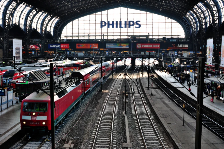 trains are sitting inside of an empty train station