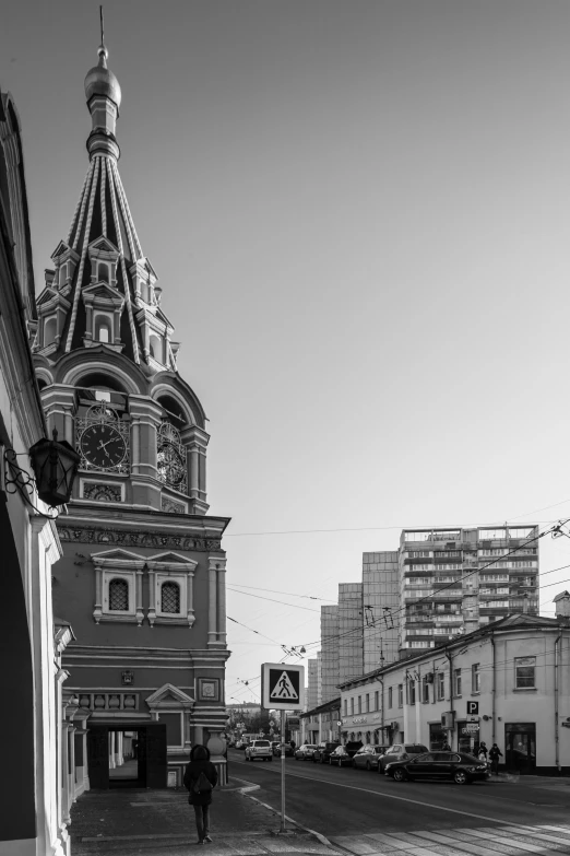 a man walking across a street next to tall buildings