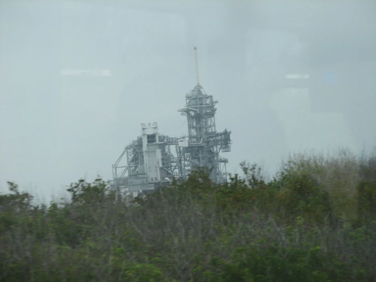 a view out the window of a factory building on top of a hill