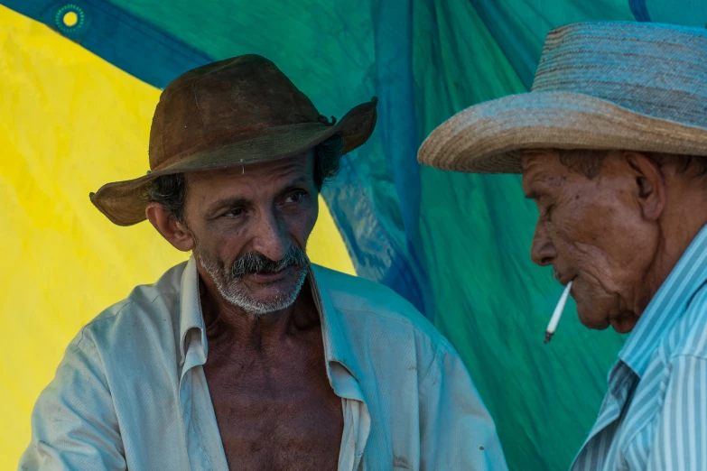 an old man smoking and smoking a cigarette while another looks on