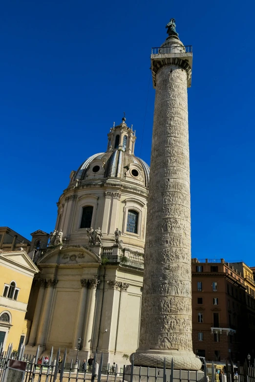 a tall grey pillar sitting next to a tall building