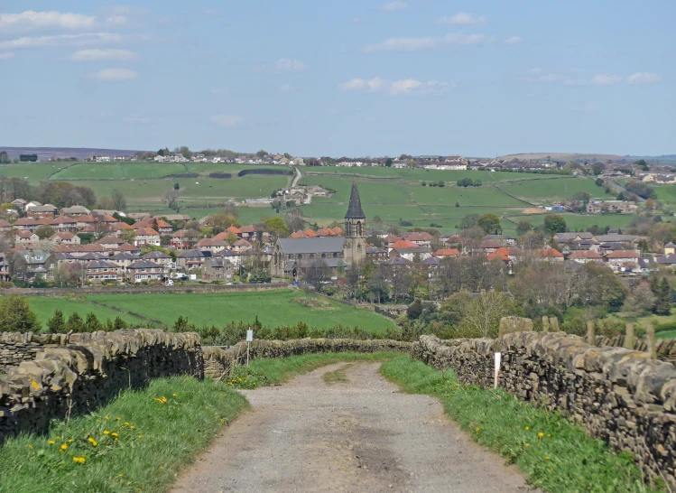 a view of buildings and mountains, with a road going through it