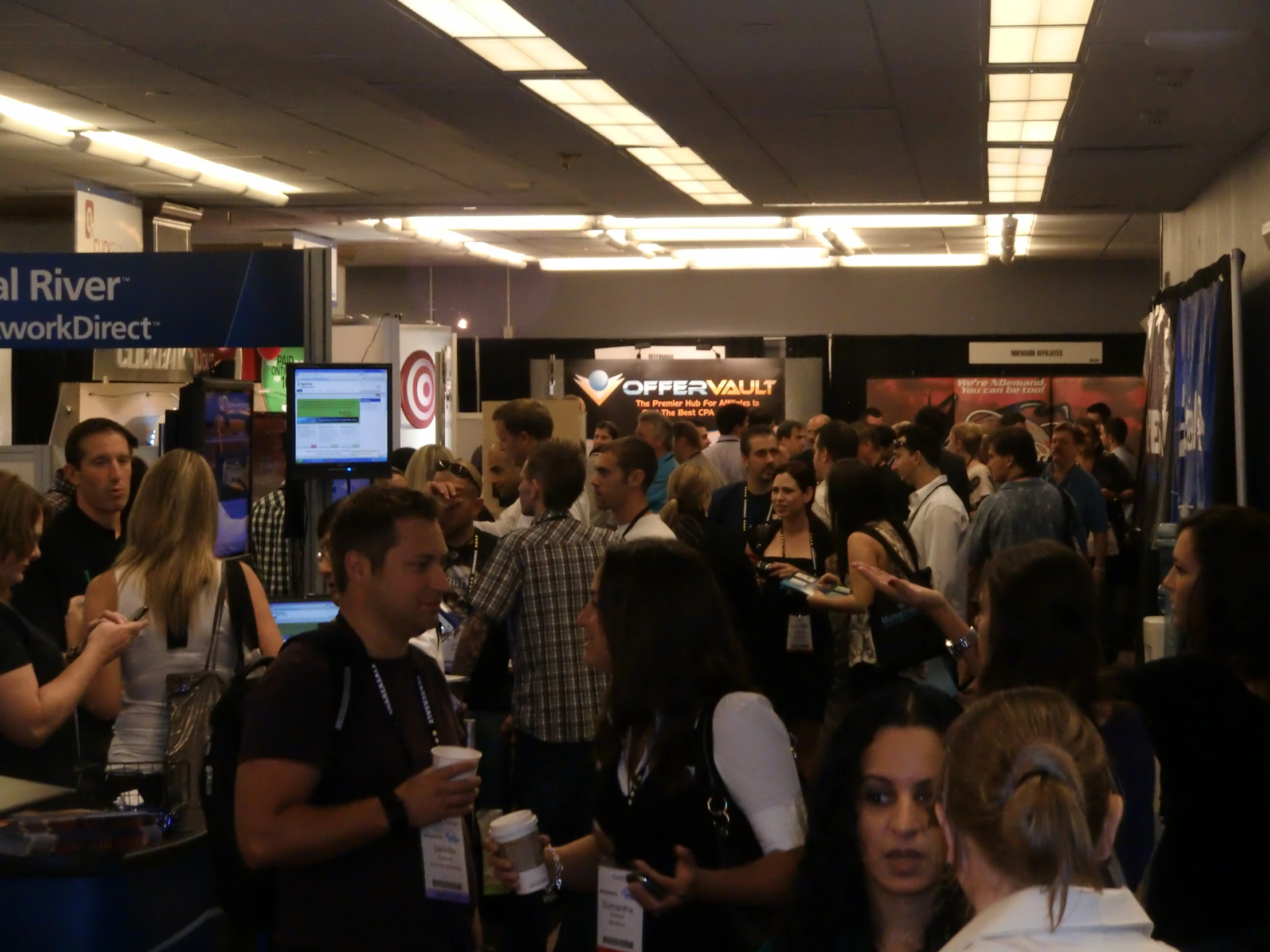 many people stand in a crowded terminal at a convention