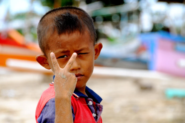 a little boy making the sign with his hand