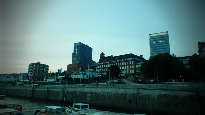 a boat docked in a river in front of some tall buildings