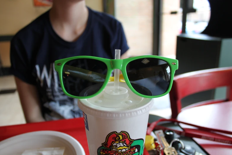 an iced drink with a pair of glasses attached to the cup