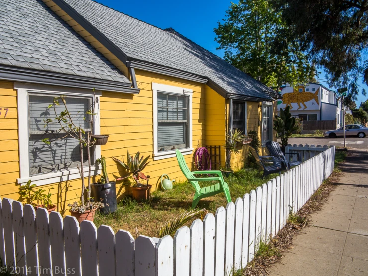 the yellow building has white picket fence