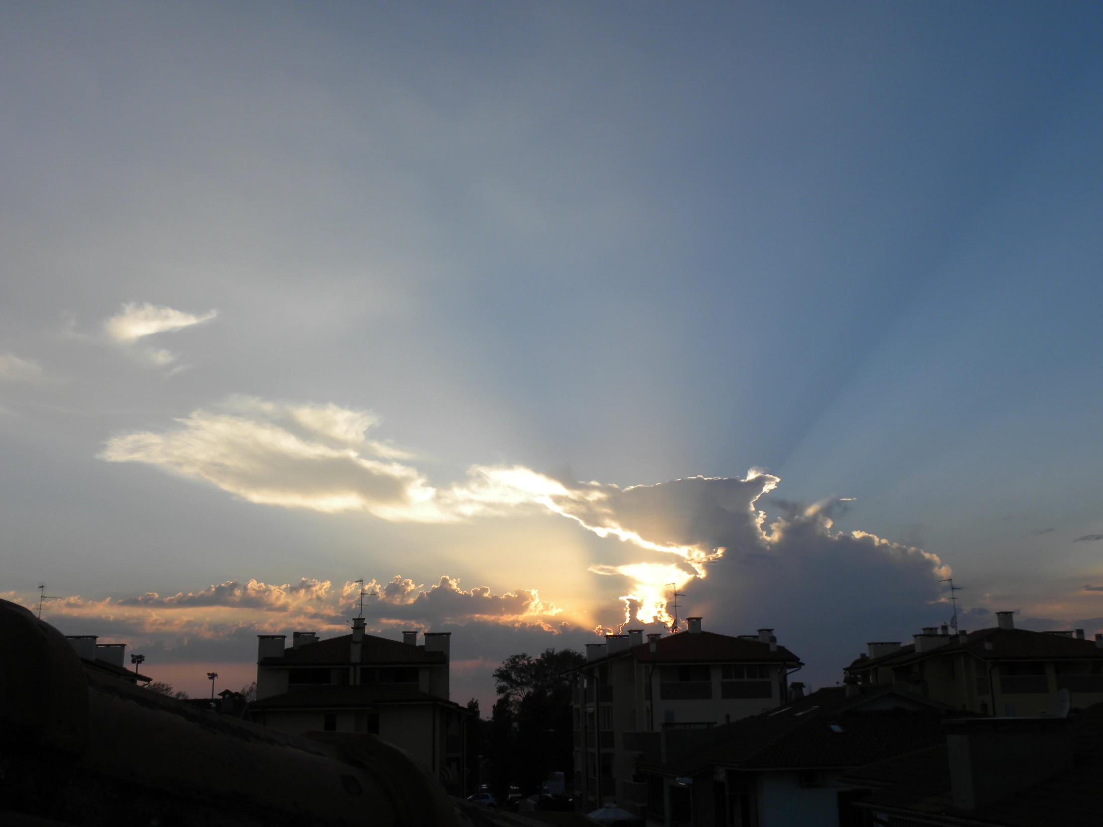 the sky is covered with a few clouds as the sun sets